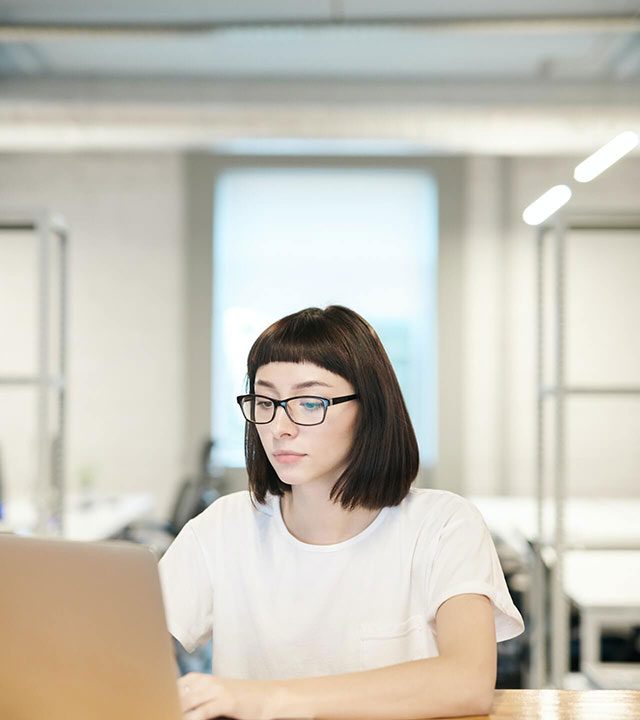 a women sitting in front of a computer concentrating on her work
